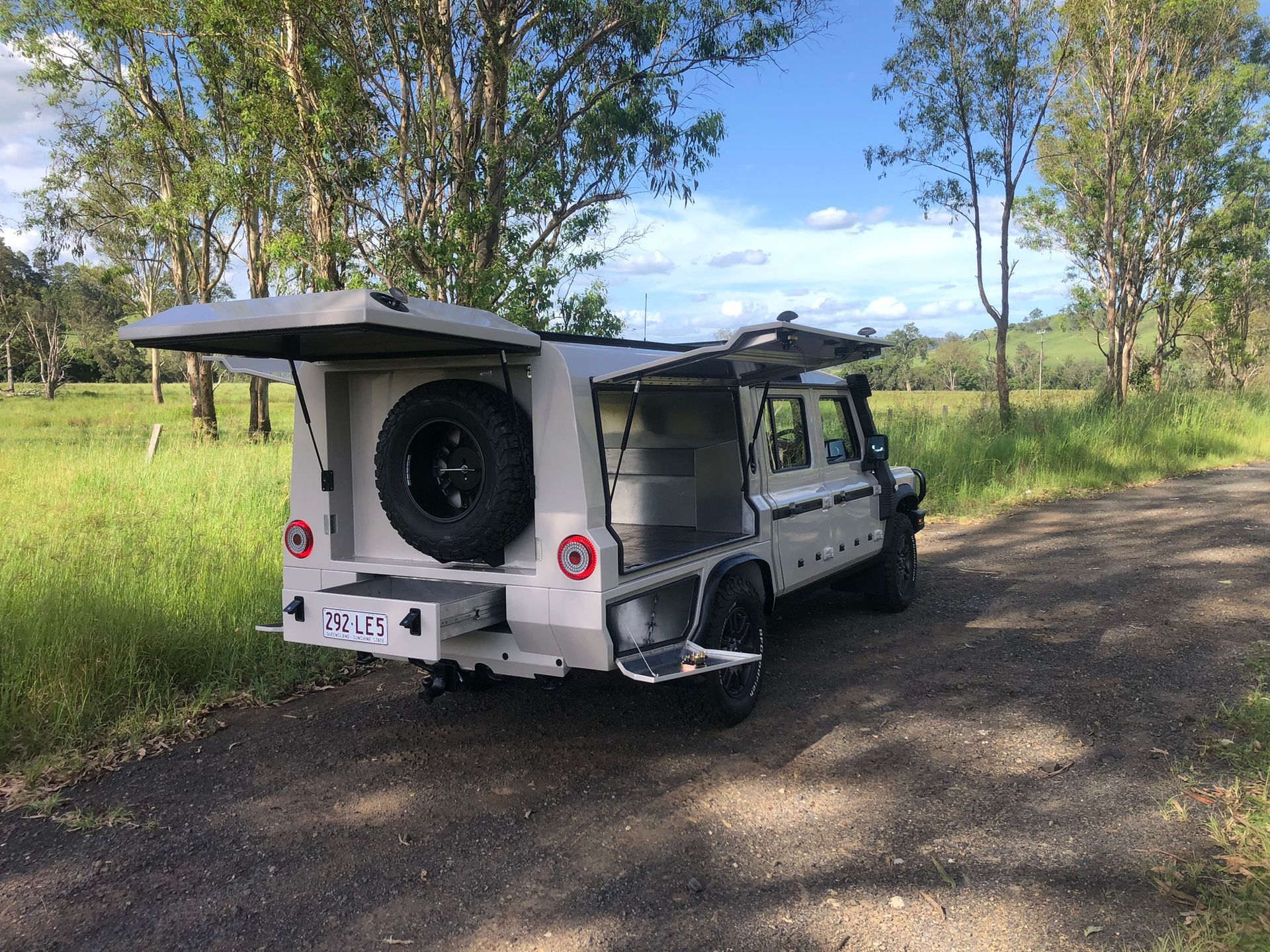 Tan 4x4 Truck With A Custom Camper On A Gravel Road — Soward Steel & Aluminium Fabrication in Casino, NSW