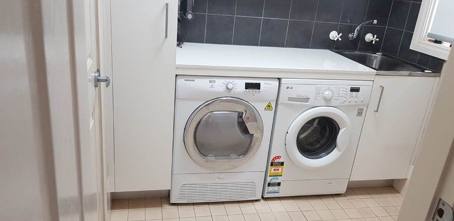 stone laundry counter with tile backsplash
