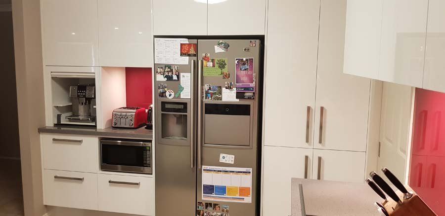 kitchen with white cupboards and red accents