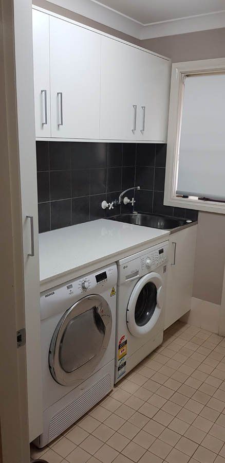 laundry counter with dark backsplash