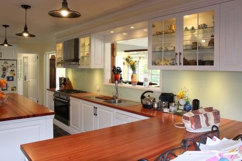 brown wood counter top and white cabinets