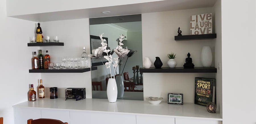 dark shelves and mirror with flower