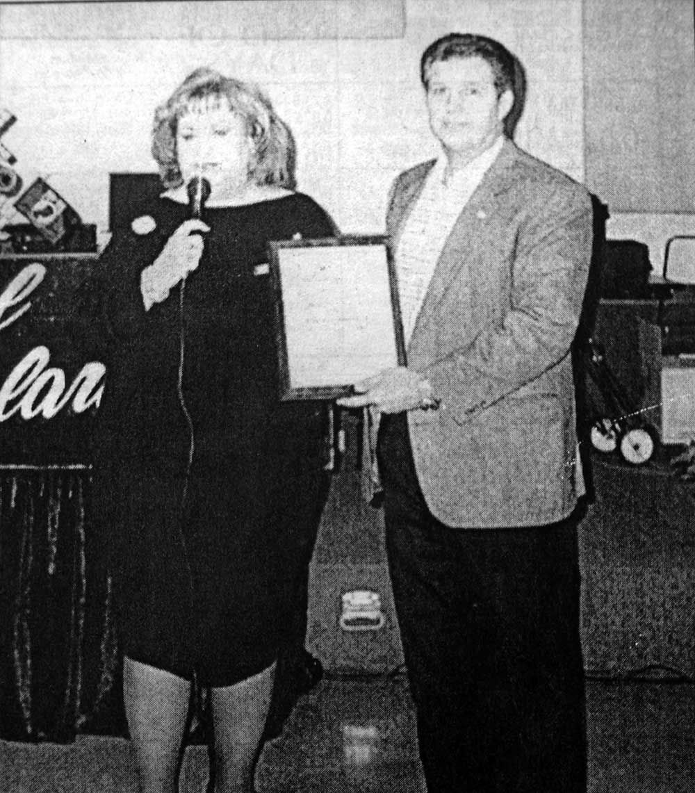 A black and white photo of a woman giving a presentation