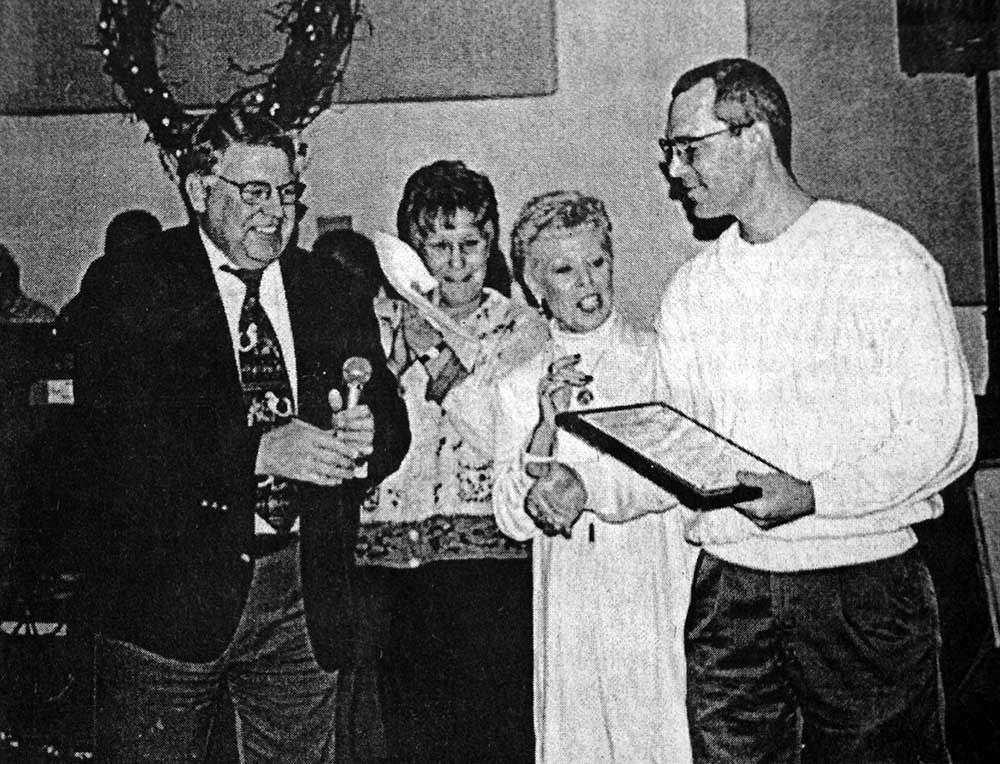 A black and white photo of a man holding a certificate