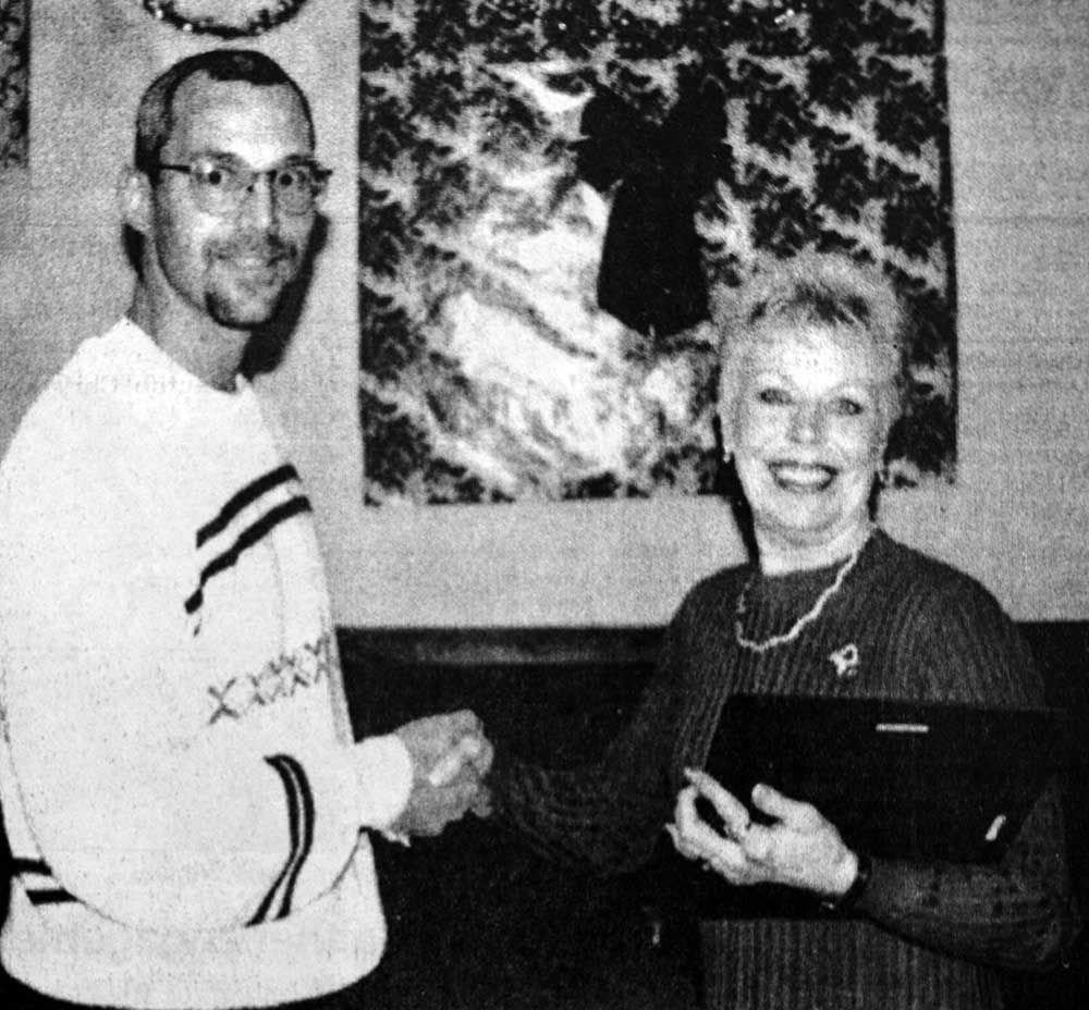A black and white photo of a man and woman shaking hands