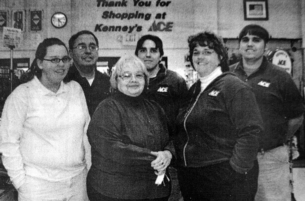 A group of people standing in front of a sign that says