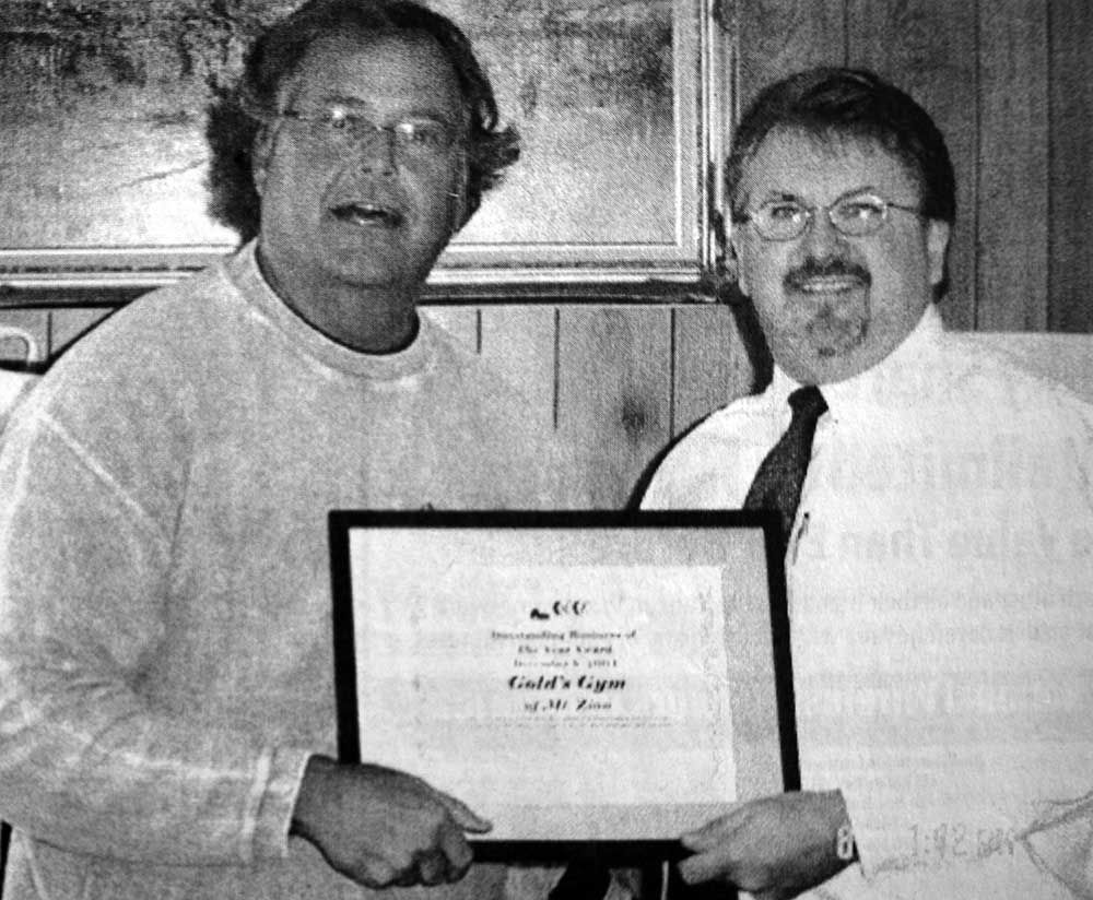 Two men are holding a framed certificate that says ' cold 's ridge ' on it