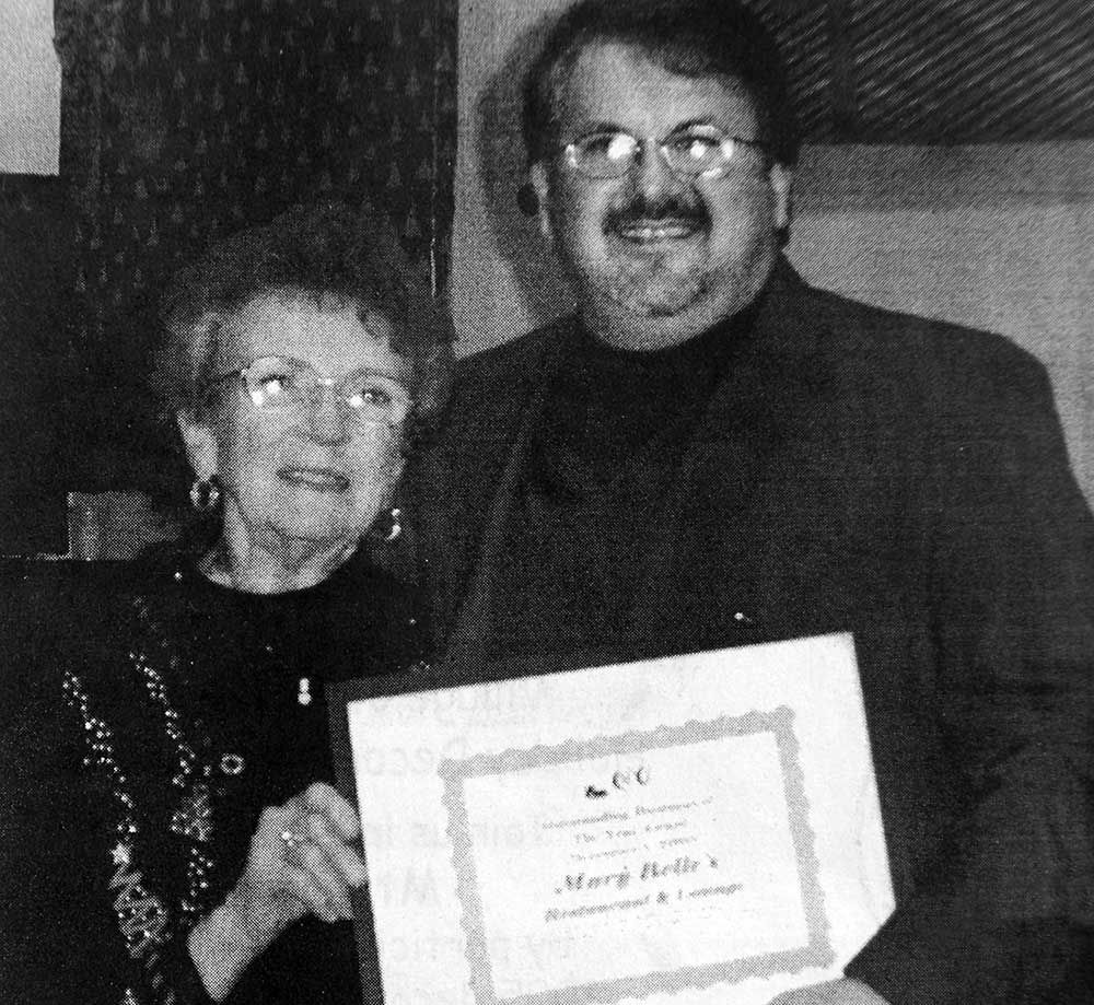 A man and woman holding a certificate that says mary belle