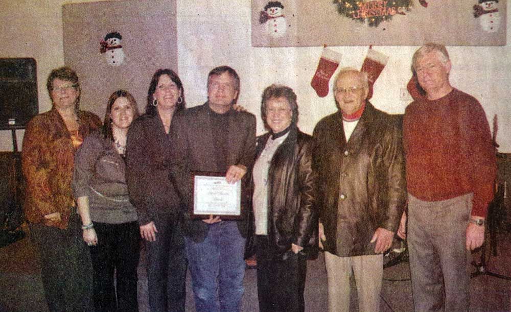 A group of people standing next to each other holding a certificate