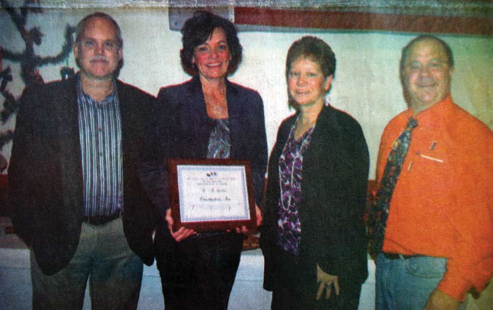A group of people standing next to each other holding a certificate