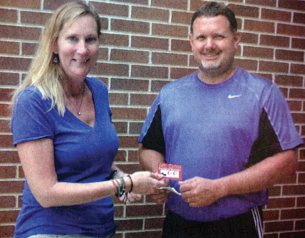 A man and a woman are shaking hands in front of a brick wall