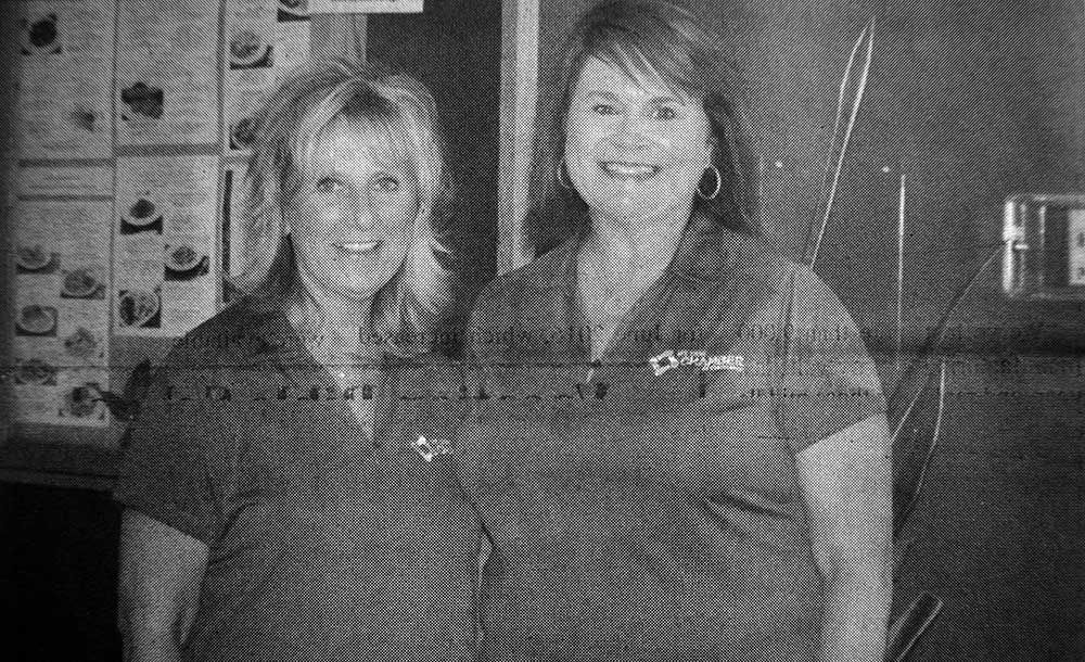 Two women are standing next to each other in a black and white photo.