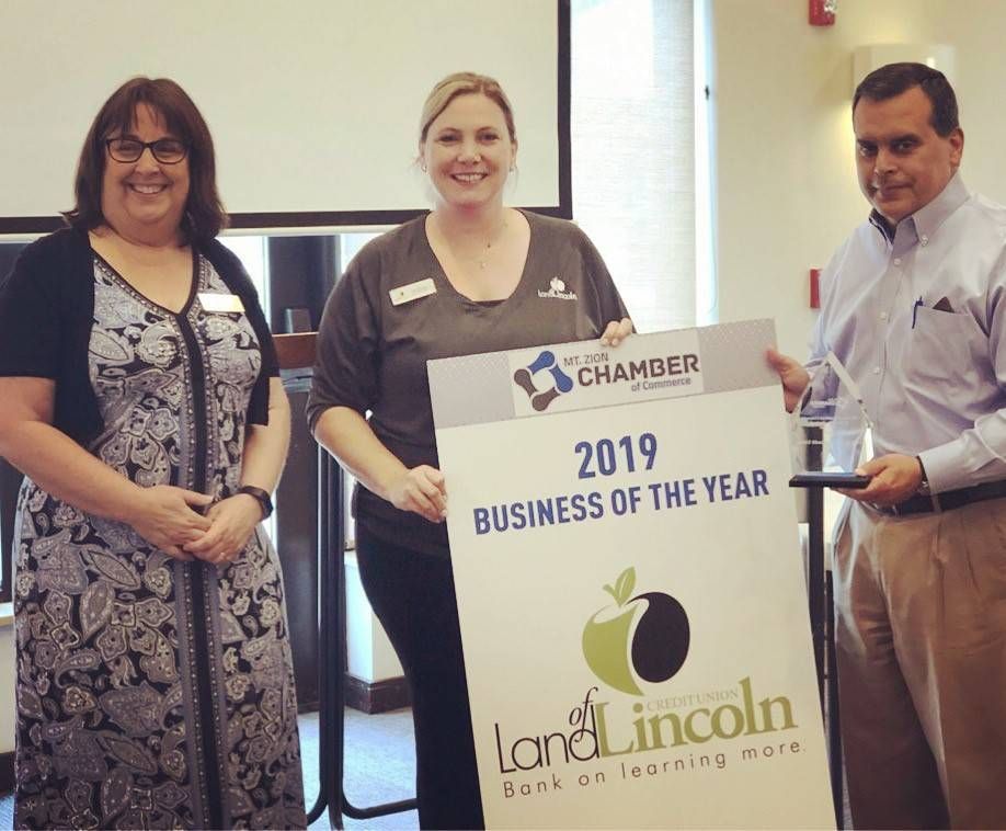 Three people holding a sign that says 2019 business of the year
