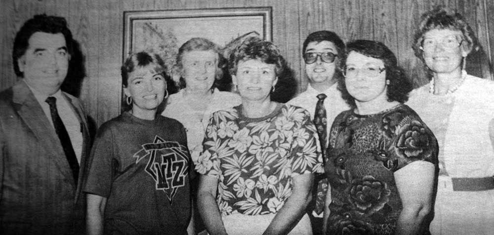A black and white photo of a group of people posing for a picture