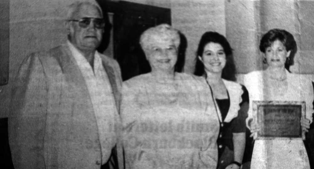A black and white photo of a family standing next to each other.