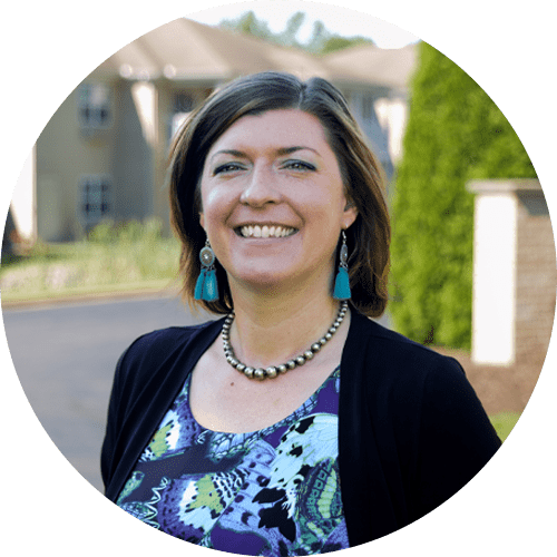 A woman wearing a necklace and earrings is smiling in a circle.