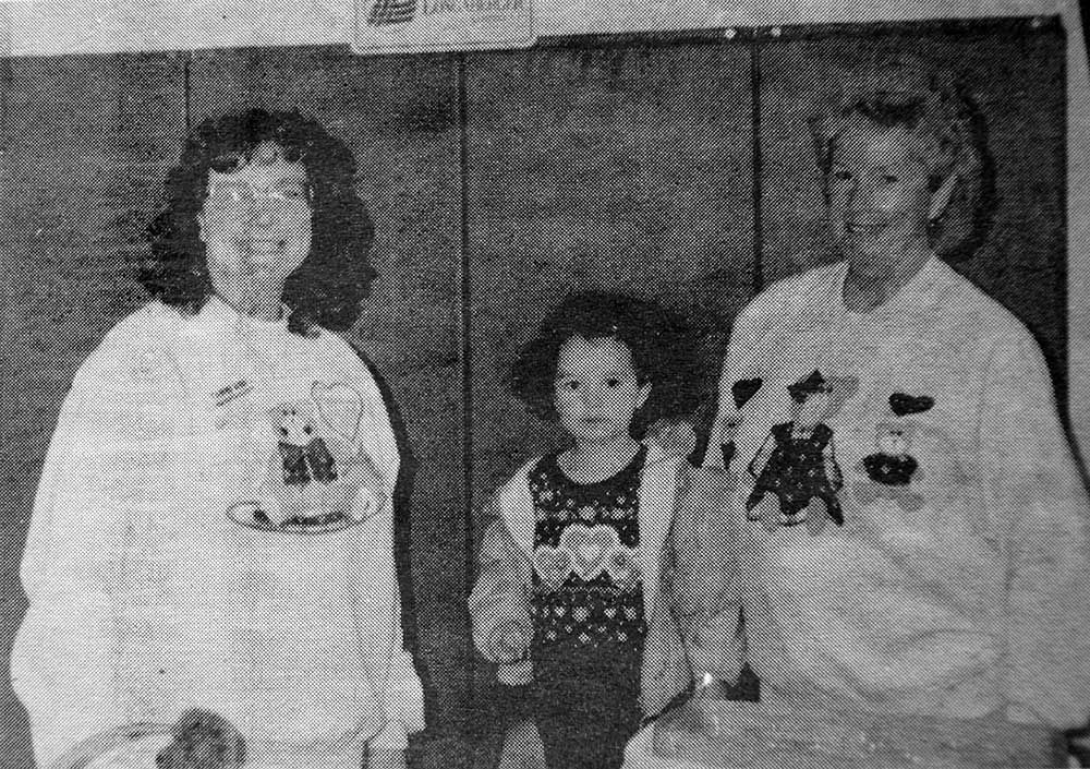 A black and white photo of three people standing next to each other.