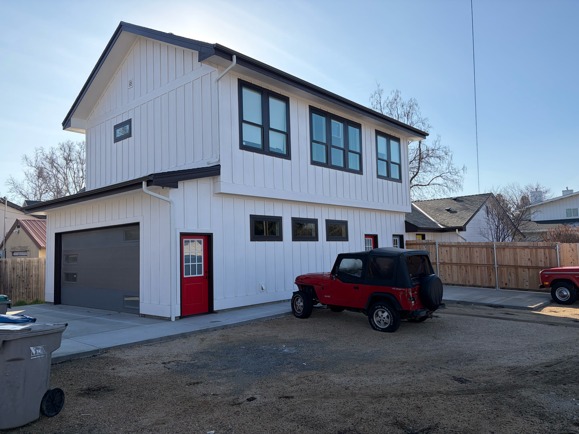 Two doves perched on a roof, against a blue sky.