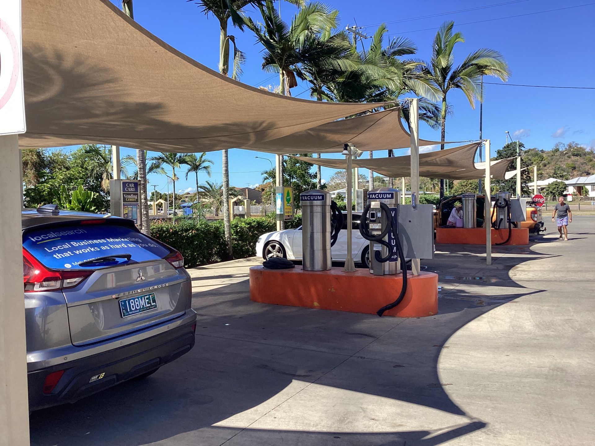 A car wash with several vacuum stations under a beige shade, on a sunny day.— Whitsunday Wash In Bowen, QLD