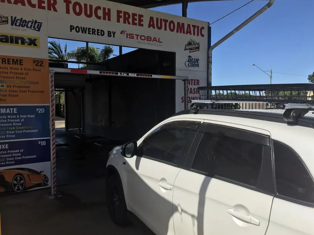 A White Car Is Parked in Front of A Sign that Says Touch Free Automatic — Whitsunday Wash In Bowen, QLD
