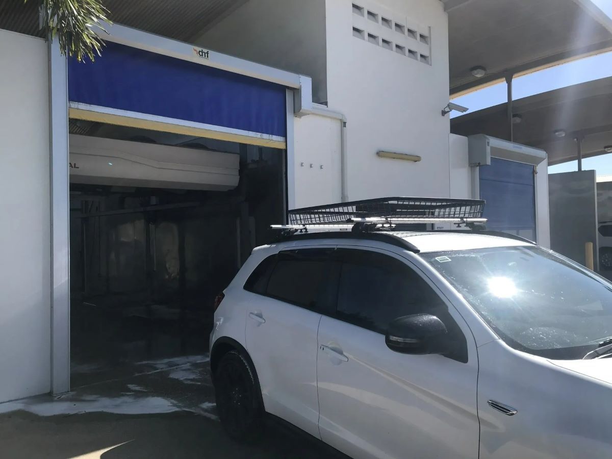 A White SUV with A Roof Rack Is Parked in Front of A Building — Whitsunday Wash In Bowen, QLD