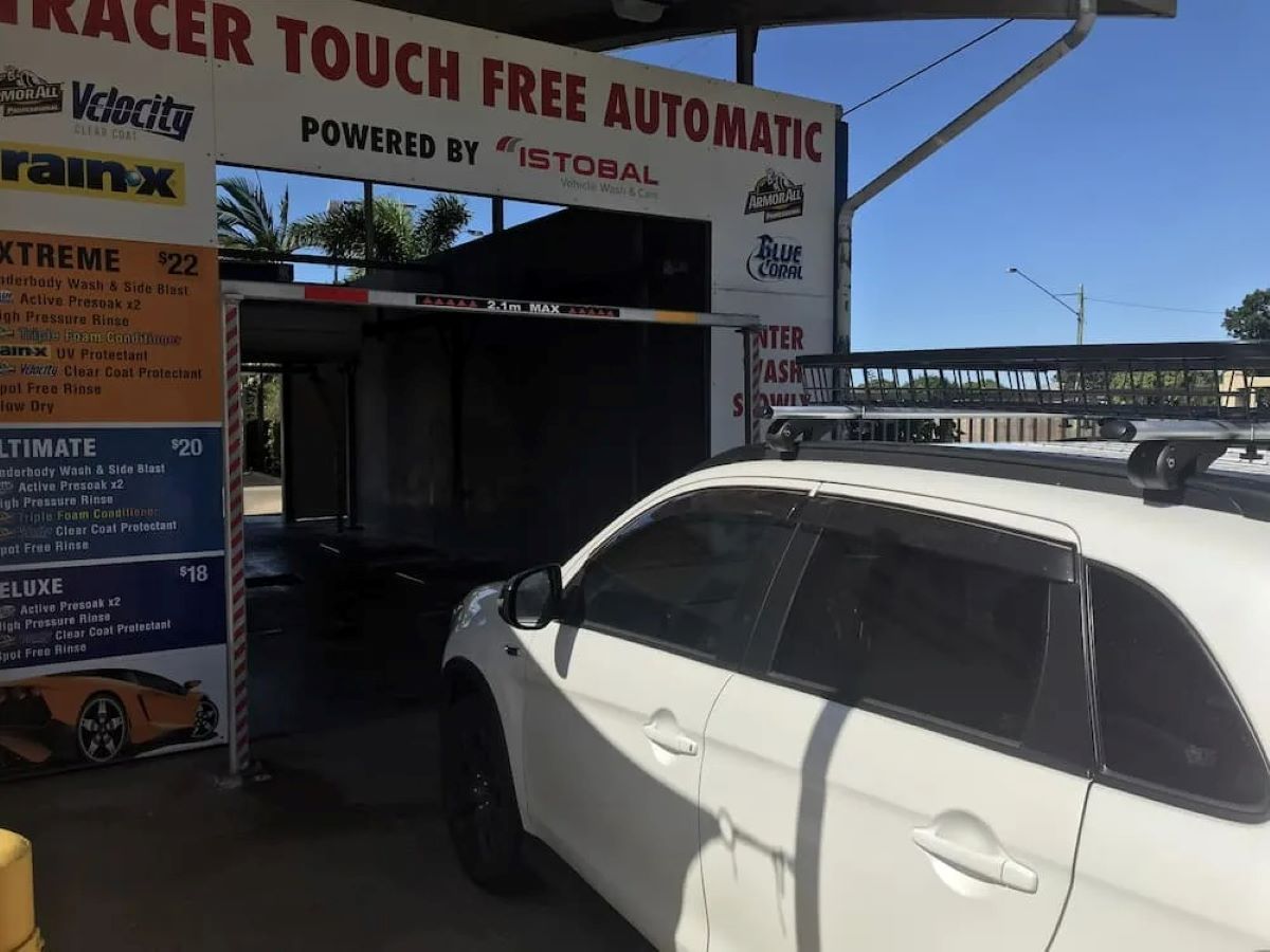 A White Car Is Parked in Front of A Sign that Says Racer Touch Free Automatic — Whitsunday Wash In Bowen, QLD