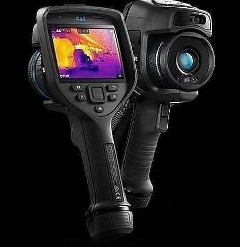 Hand holding a thermal imaging camera, displaying a heat map of a staircase.