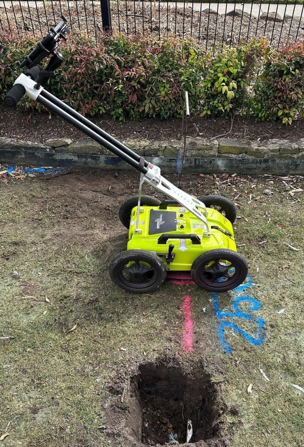 Orange case and equipment near a brick wall and concrete floor with white markings and shadows.