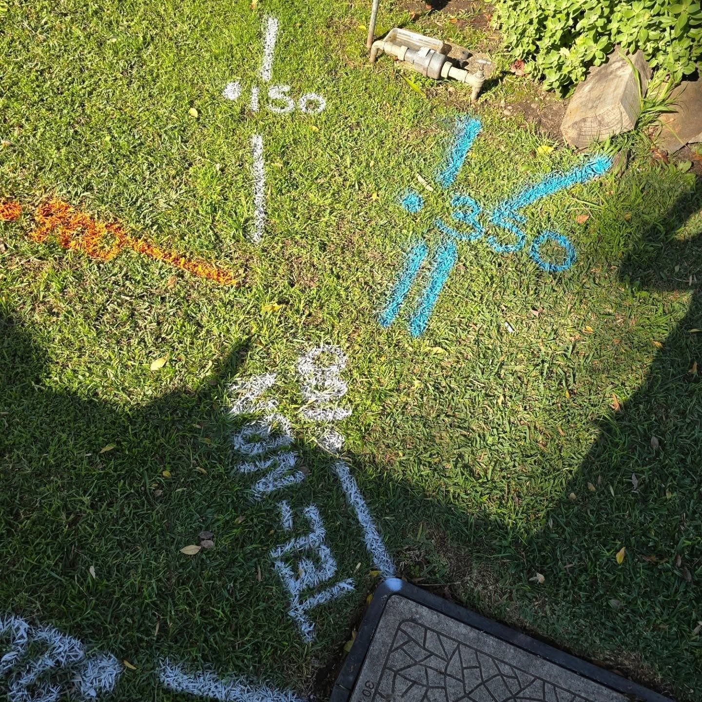 Parking lot with orange traffic cones, curb, and sunlit background of hills and sky.