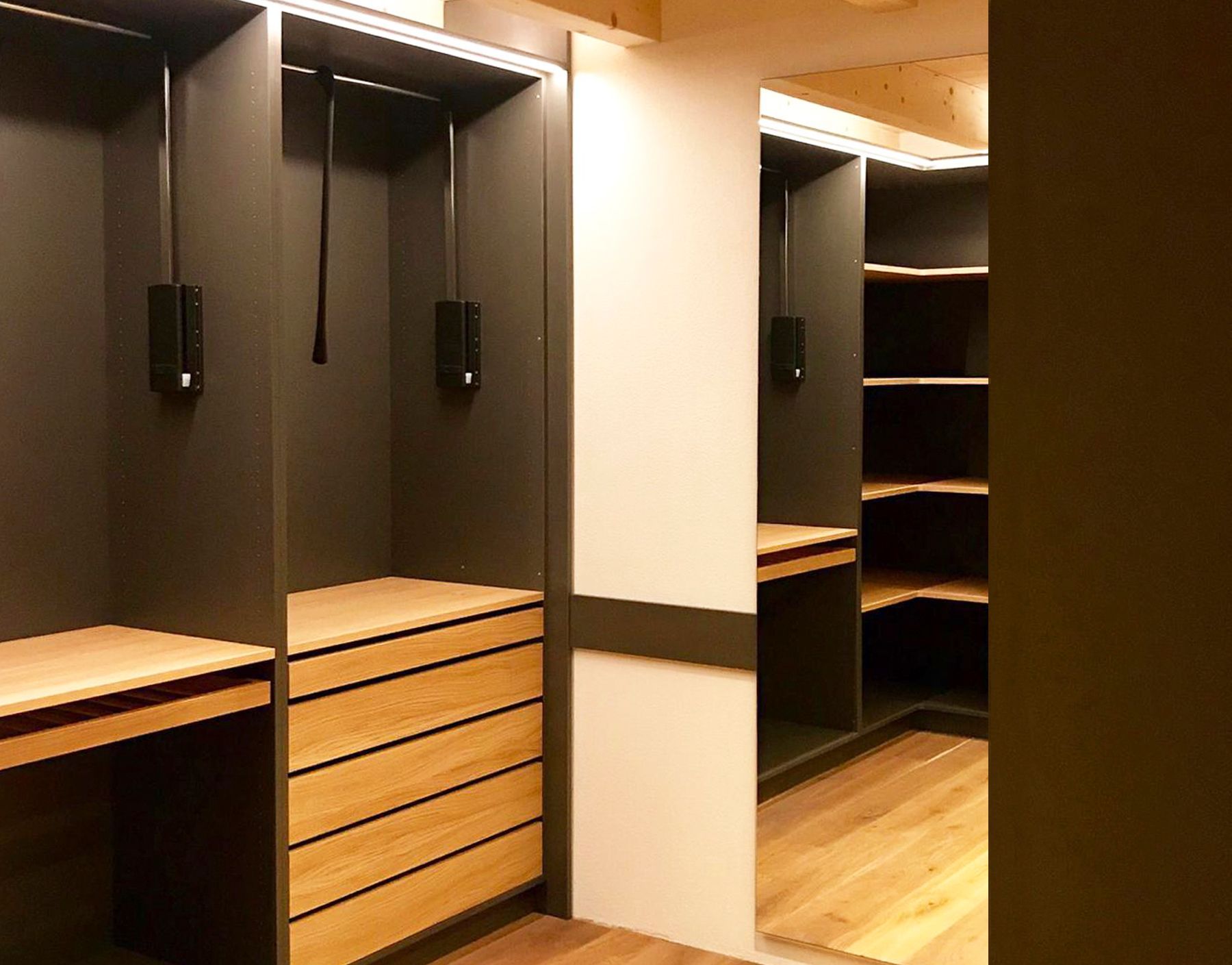 Ein begehbarer Kleiderschrank mit Holzschubladen und Regalen