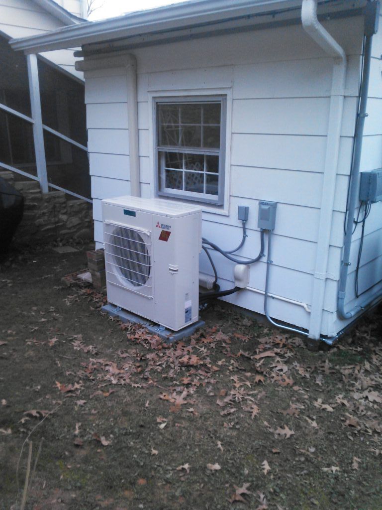 A white house with a large air conditioner on the side of it.