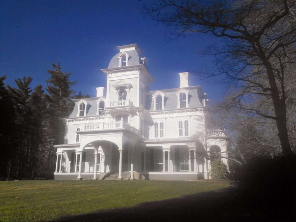 A large white house with a blue sky in the background