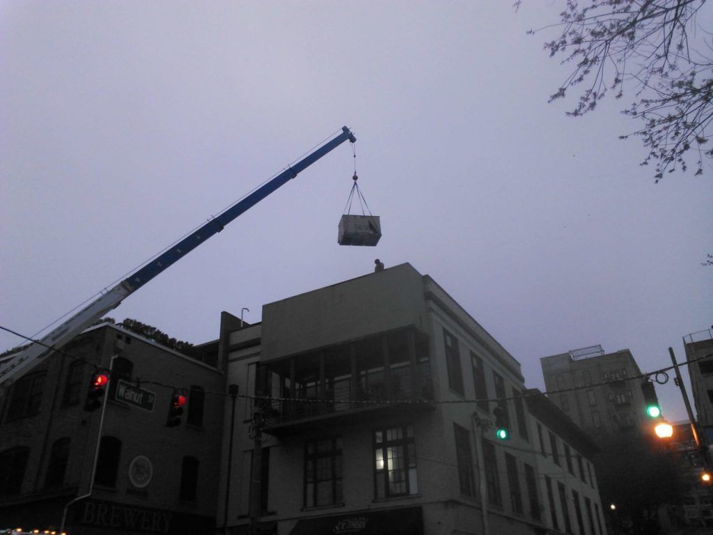 A crane is lifting a large object over a building