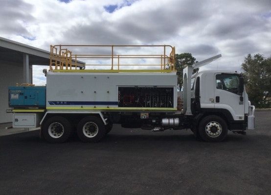 A white truck with a yellow roof is parked in a parking lot.