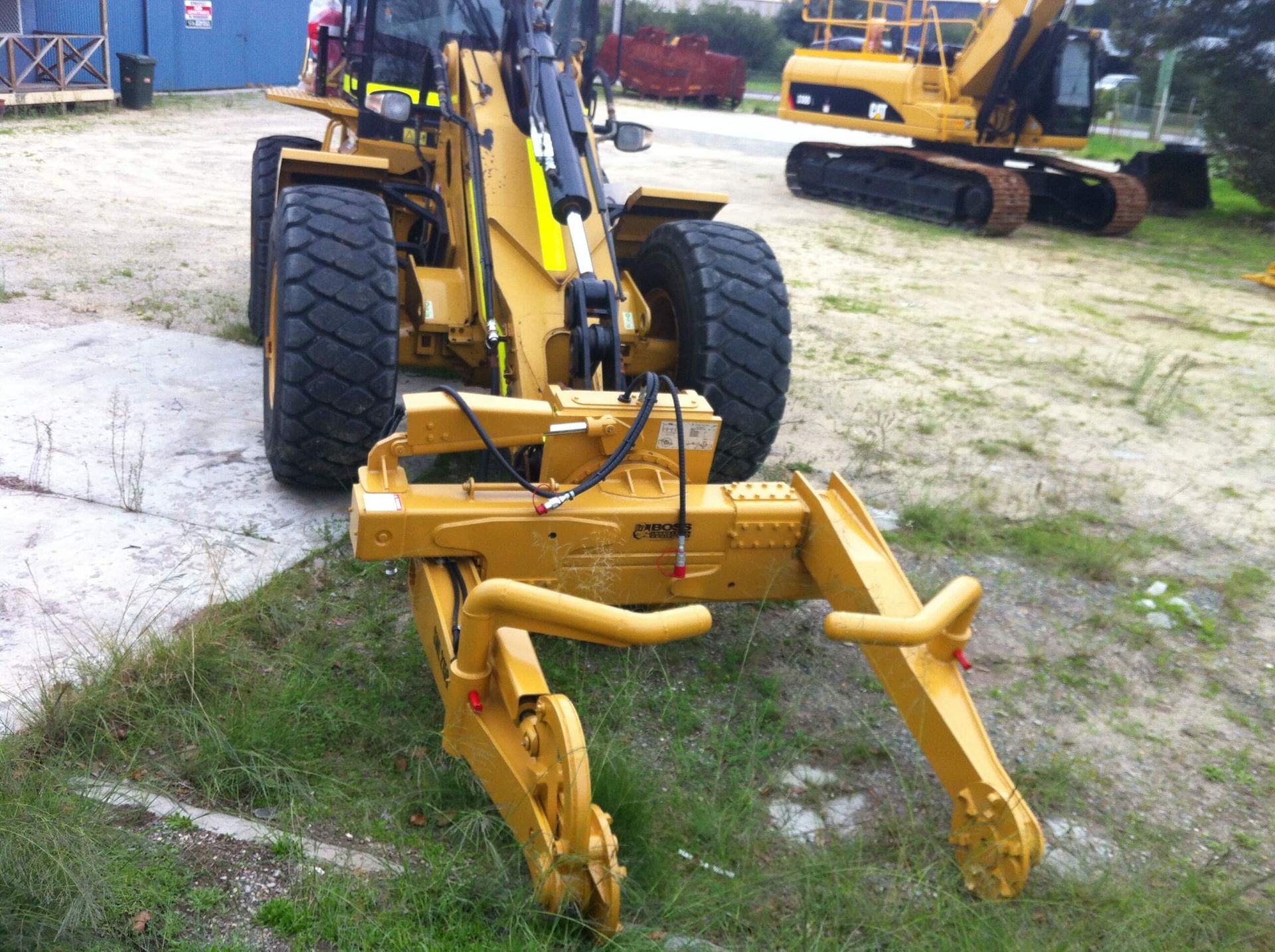 A yellow tractor is parked in a grassy area
