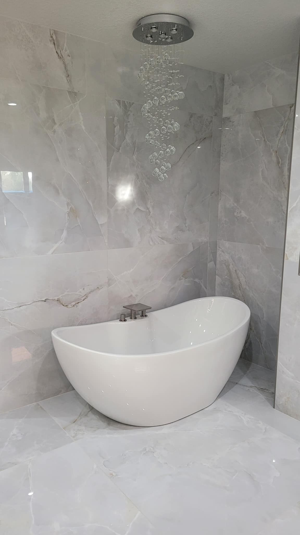 A white bathtub is sitting in the corner of a bathroom next to a shower.