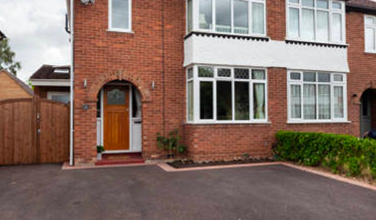 a brick house with a large driveway in front of it .