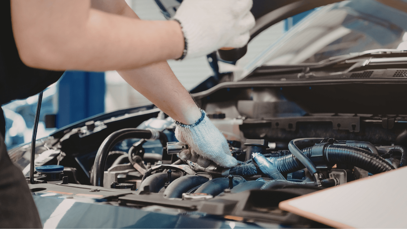 a mechanic inspecting under the hood of a car