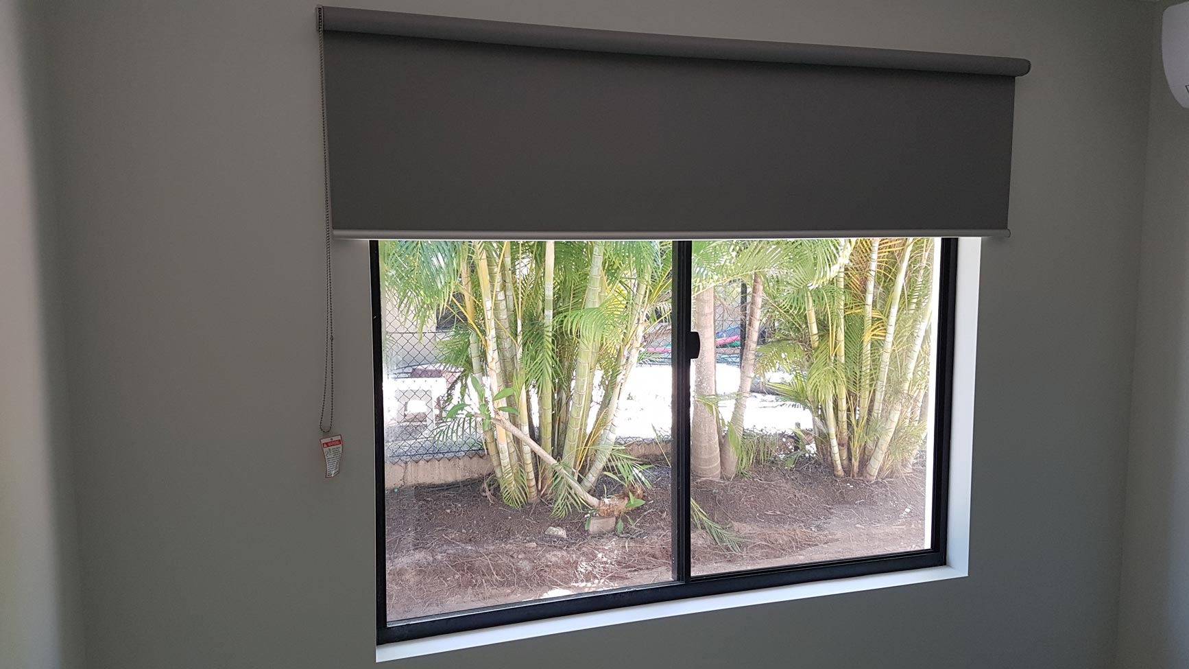 Sliding Window With Gray Roller Blinds — Blinds Installation in Winnellie, NT
