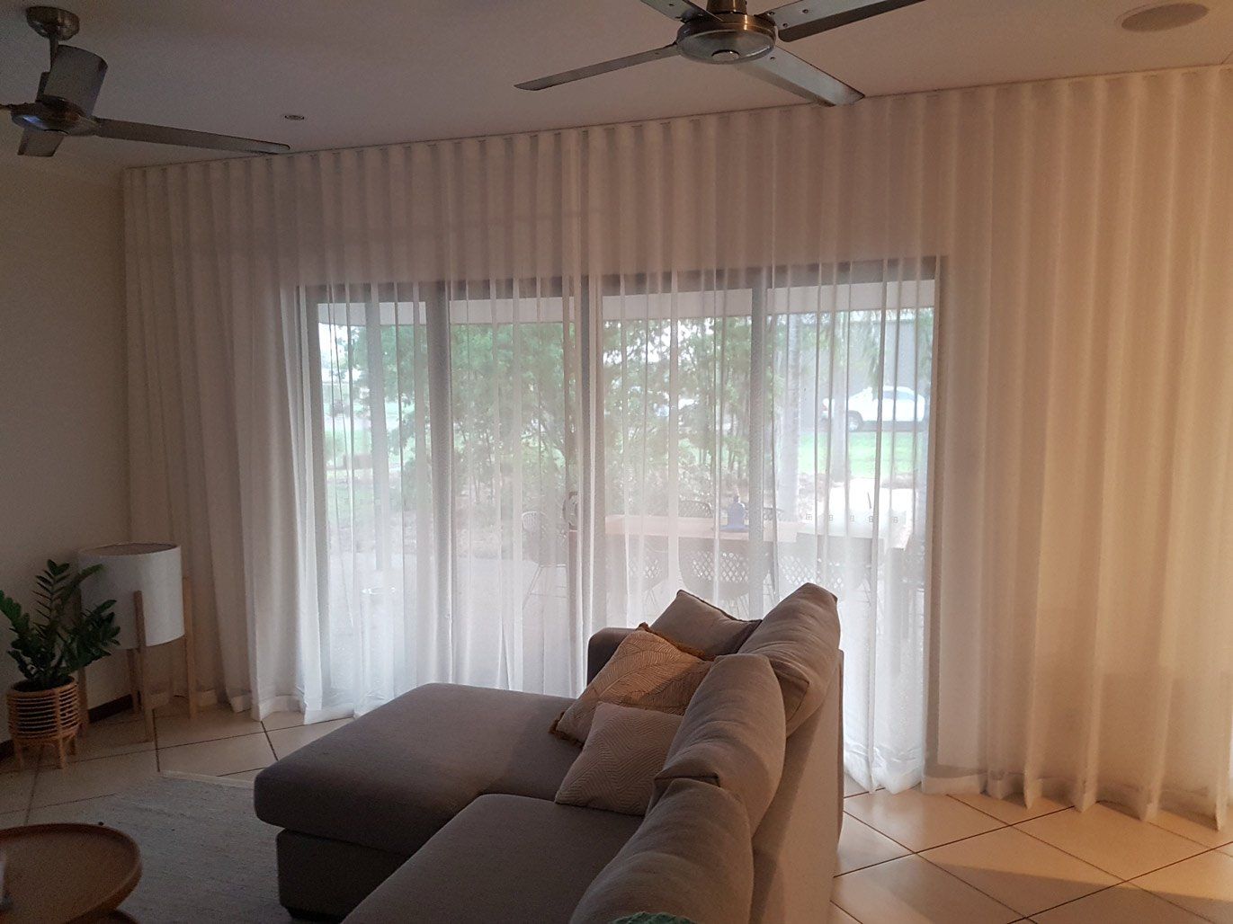 Room With White Mesh Curtains Near Couch — Blinds Installation in Winnellie, NT