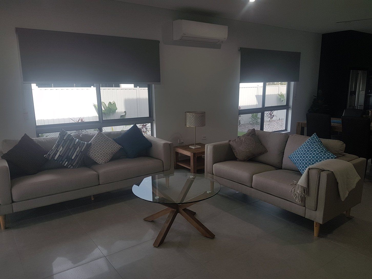 Living Room With Couch And Glass Table — Blinds Installation in Winnellie, NT