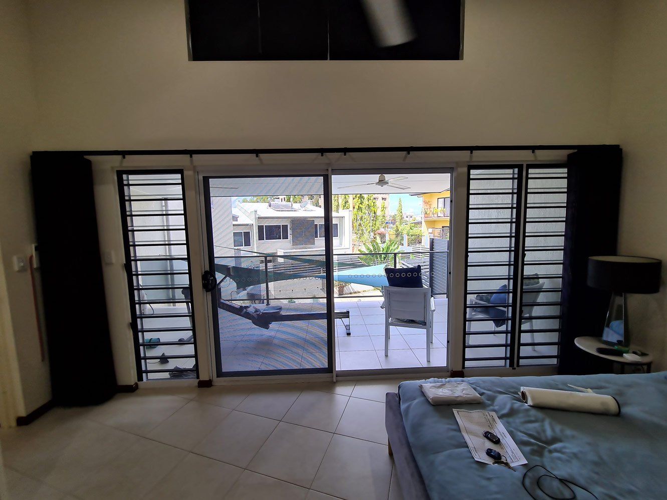 Bedroom With Sliding Door To Balcony — Blinds Installation in Winnellie, NT