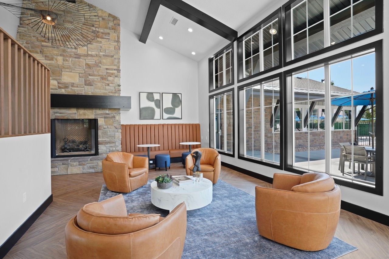 Modern communal lounge with stone fireplace, leather seating, and large windows
