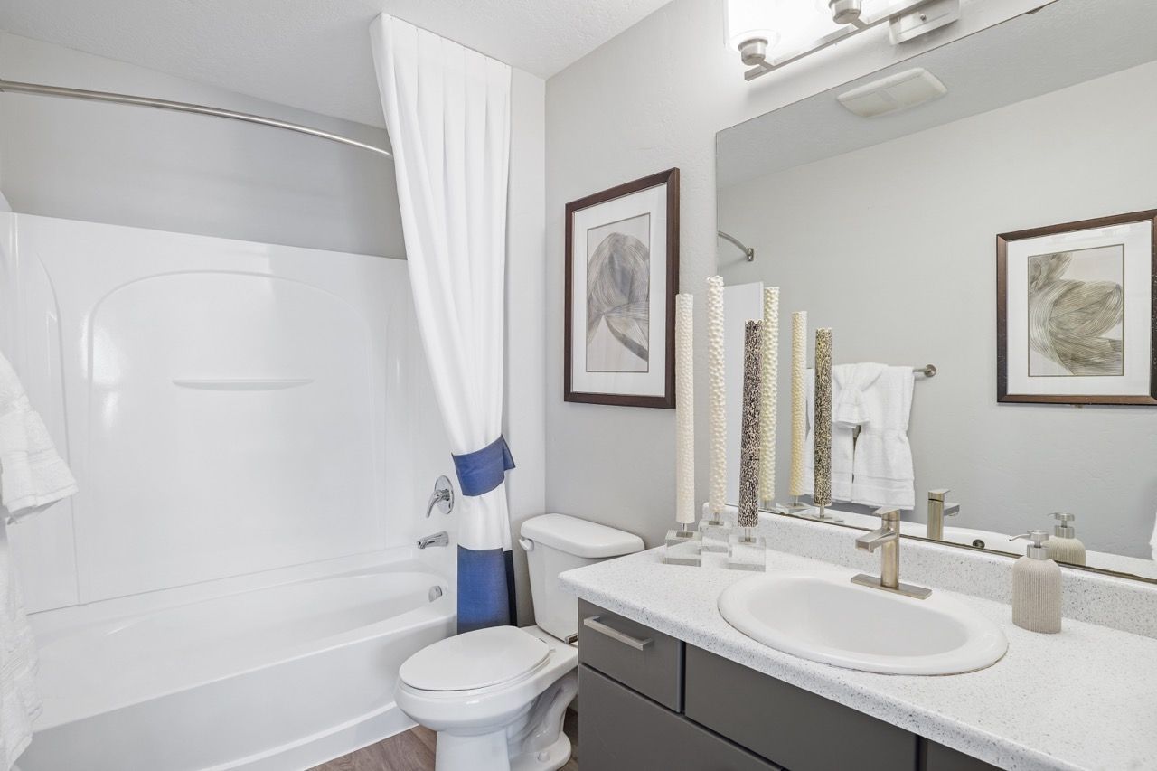 Bathroom with tub/shower, toilet, and modern vanity with sink.