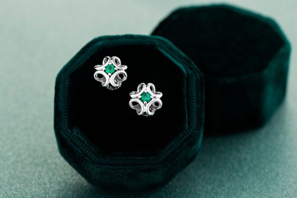 Orecchini di smeraldi in una scatola portagioie di velluto verde scuro.