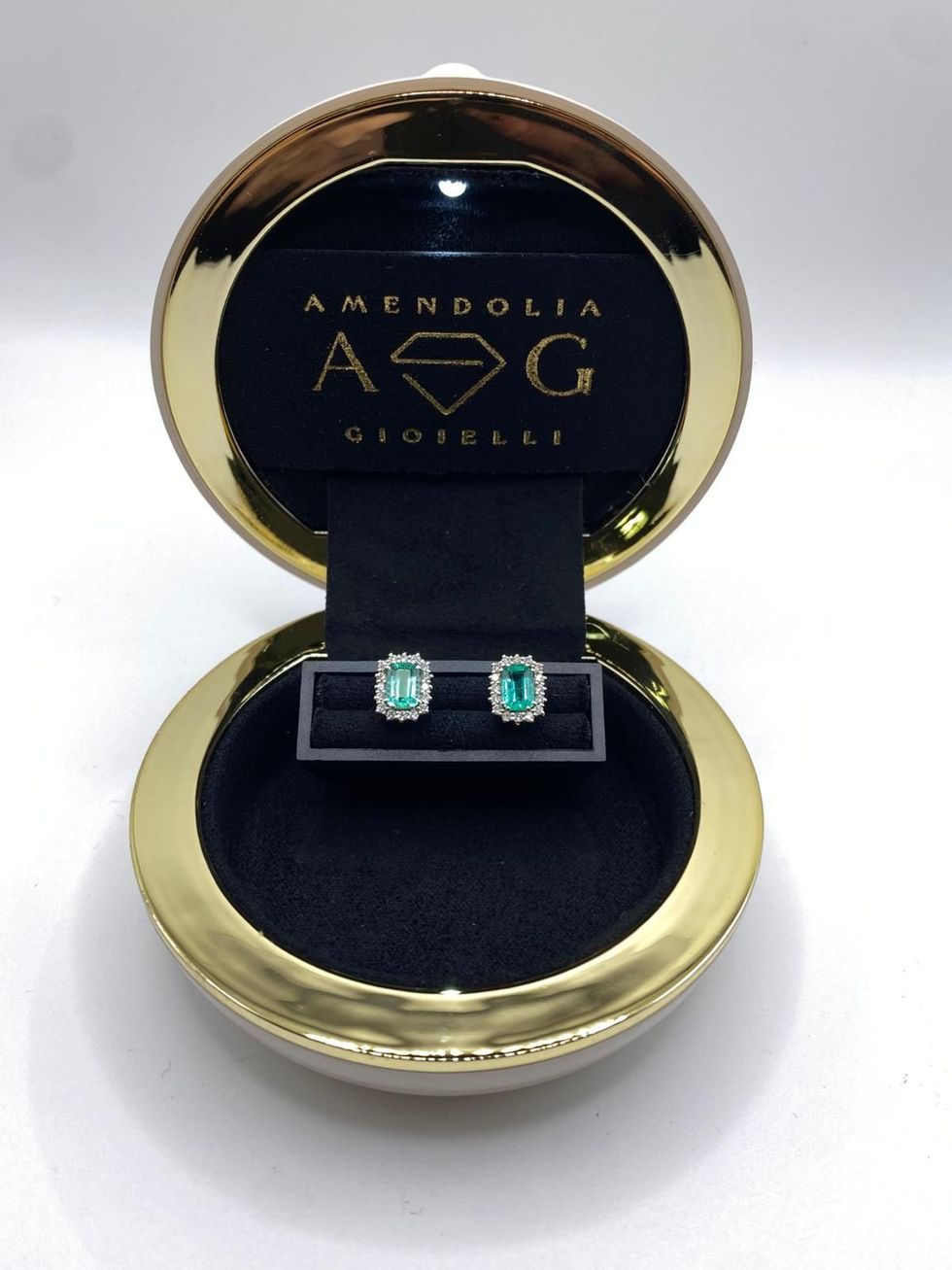 Donna che sistema un orecchino di diamanti. Primo piano dell'orecchio, della mano e del collo su sfondo nero.