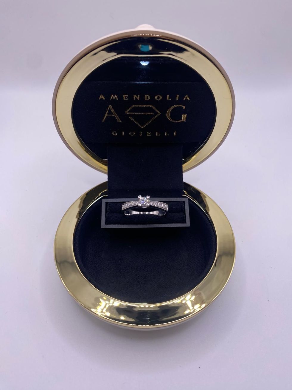 Anello di diamanti in una scatola grigia con un'etichetta che dice 