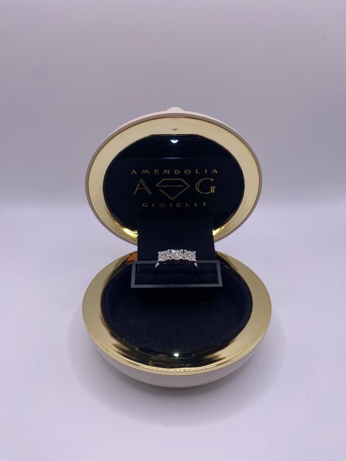 Anello all'interno di una scatola di velluto verde acqua a forma di albero di Natale con stella dorata in cima e ghirlanda.