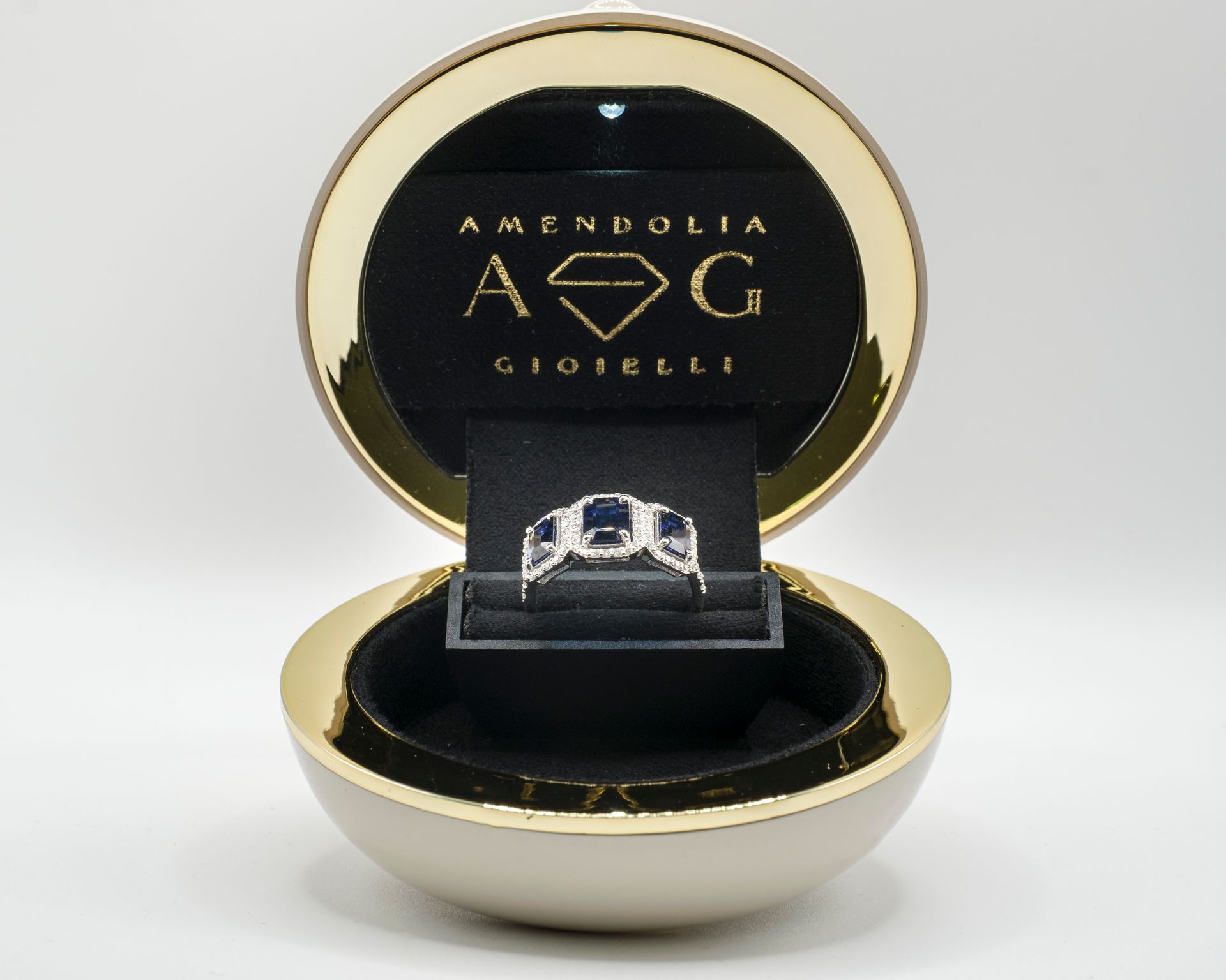 Anello in un portagioie aperto in oro con interno nero.