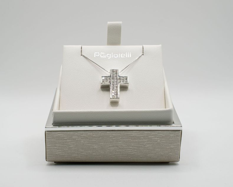 Collana con ciondolo a croce in argento in una scatola espositiva.